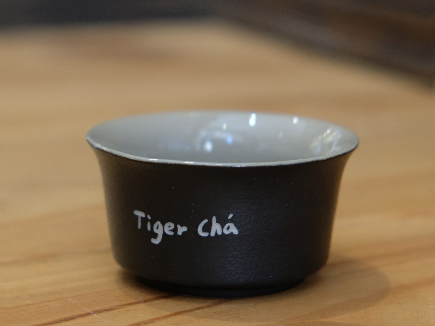 TigerCha teapot product photo with wooden handle and laser tiger crest.